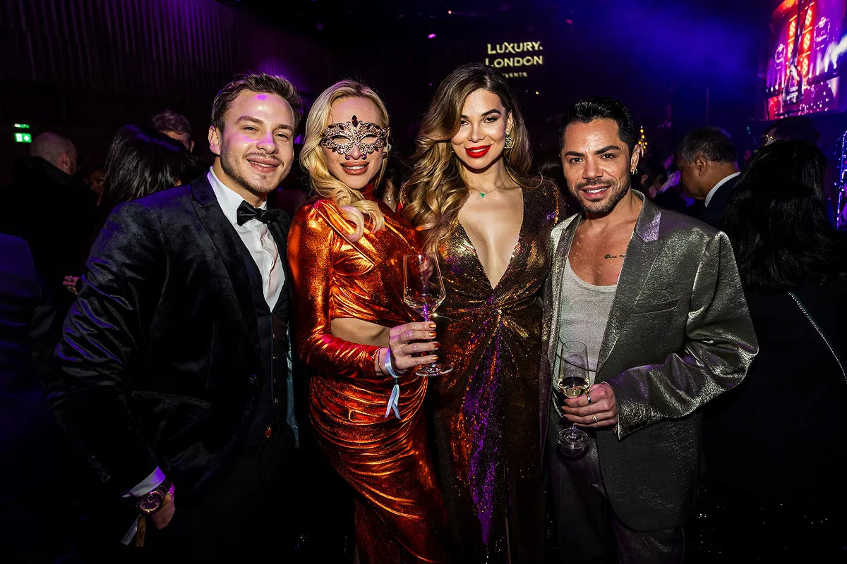 A group of glamorous guests posing together at the London New Year's Eve Masquerade ball