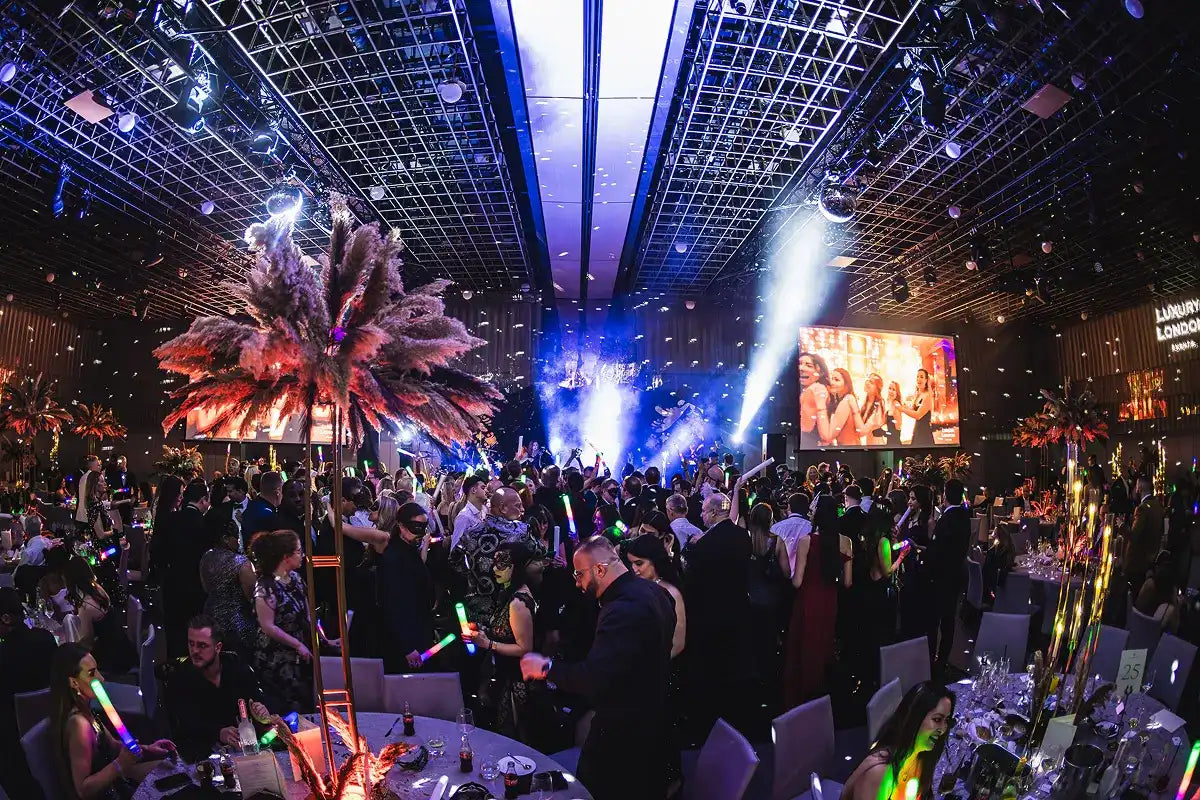 Crowd of guests with glow sticks at the London New Year's Eve Masquerade ball